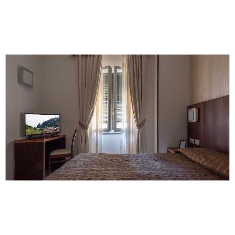 a hotel room with a bed and a television at Hotel Margherita in Monterosso al Mare