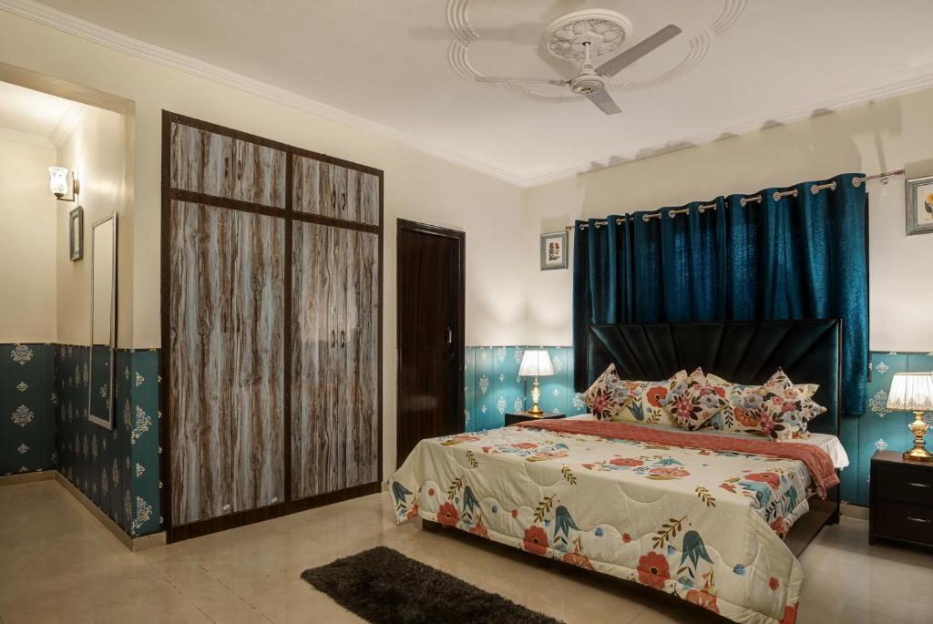 a bedroom with a bed and blue curtains at Meera Homes in Dehradun