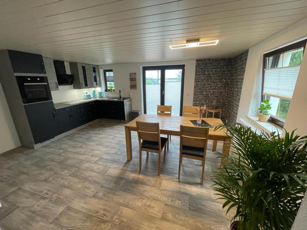 una cucina e una sala da pranzo con tavolo e sedie di Ferienwohnung Sonnenhof a Ammelsdorf
