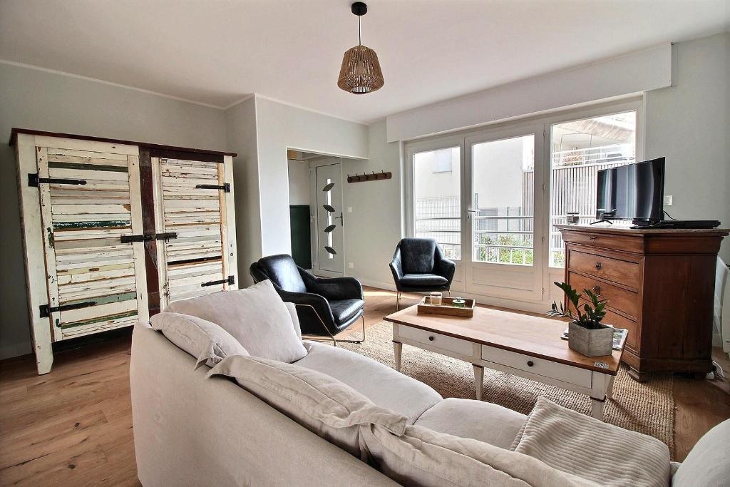 ein Wohnzimmer mit Sofa und Fernseher in der Unterkunft Maison face à Nausicaa in Boulogne-sur-Mer