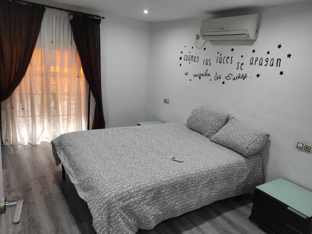 una camera da letto con un letto e un condizionatore a muro di Al-Andalus Agradable casa para relajarse y descubrir Córdoba a Cordoba