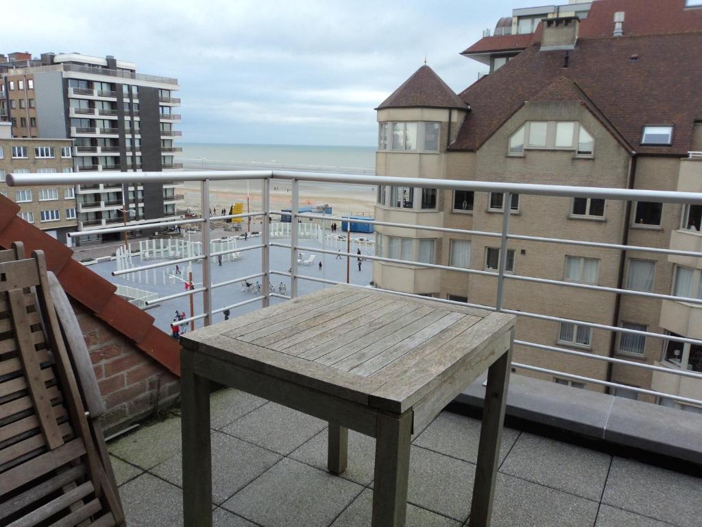 eine Holzbank auf dem Balkon in der Unterkunft For Ever in Nieuwpoort