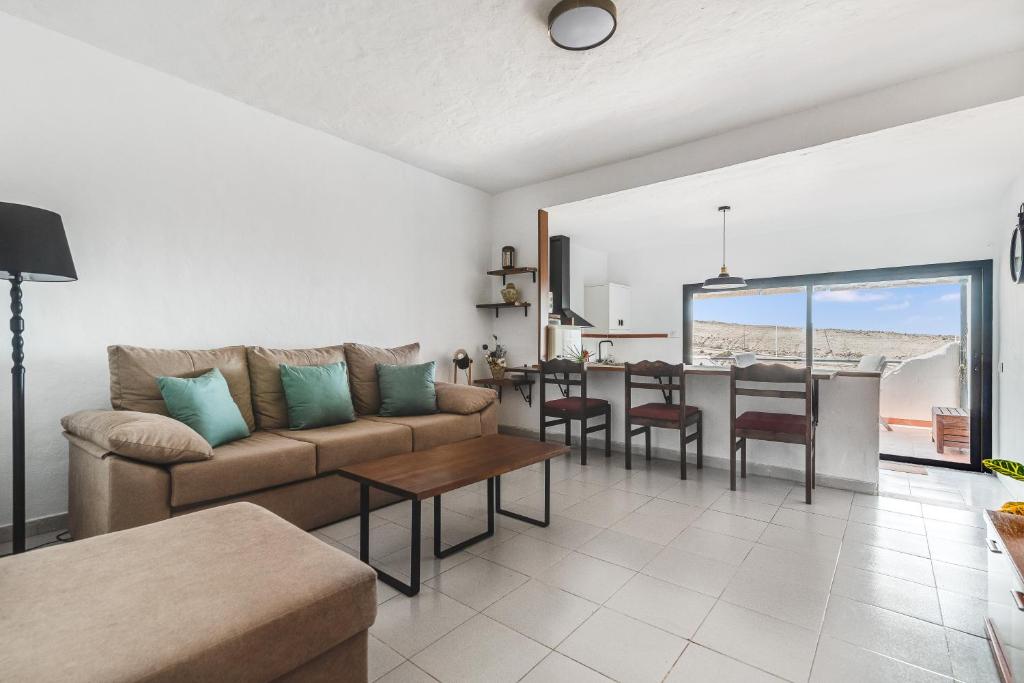 een woonkamer met een bank en een tafel bij Home2Book Cozy Sea Views Punta Sardina Lighthouse in Gáldar