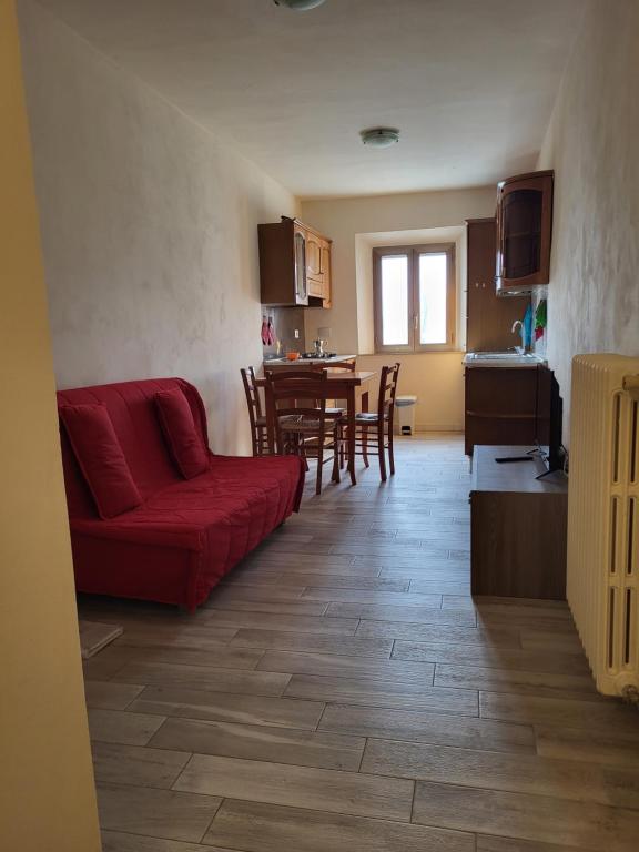 sala de estar con sofá rojo y cocina en Grazioso appartamento con deposito bici S. Miniato, en San Miniato