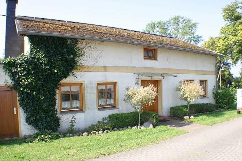 a small white house with trees in front of it at Rügen Fewo 287 in Kluis