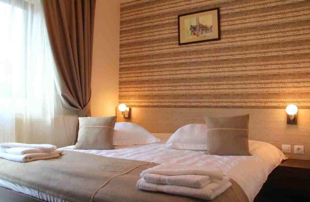 - une chambre avec un grand lit et des serviettes dans l'établissement Vila Creasta Cocosului, à Păltiniş