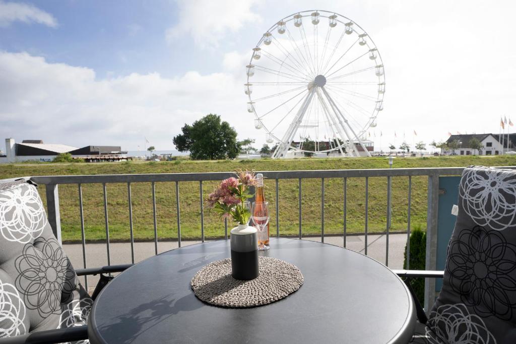 a table with a vase of flowers and a ferris wheel at Zur Düne Wohnung 8 in Dahme