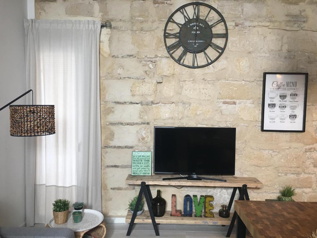 salon z telewizorem na murze w obiekcie Loft Xerez Centro w mieście Jerez de la Frontera