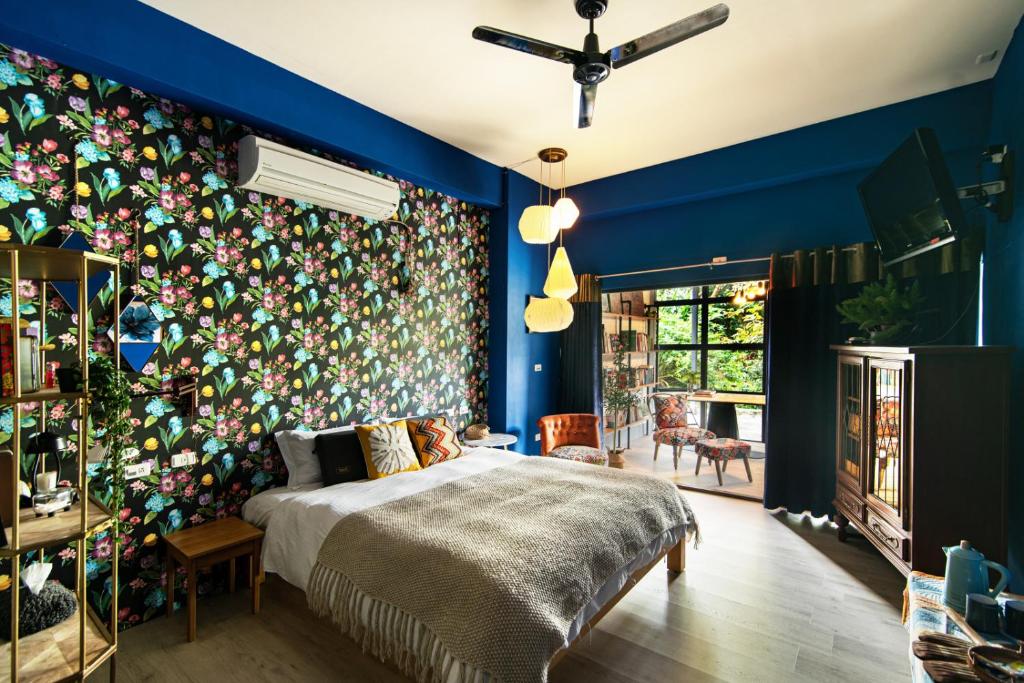 1 dormitorio con una pared colorida y 1 cama en 麵包樹舍 Breadfruit B&B en Guangfu