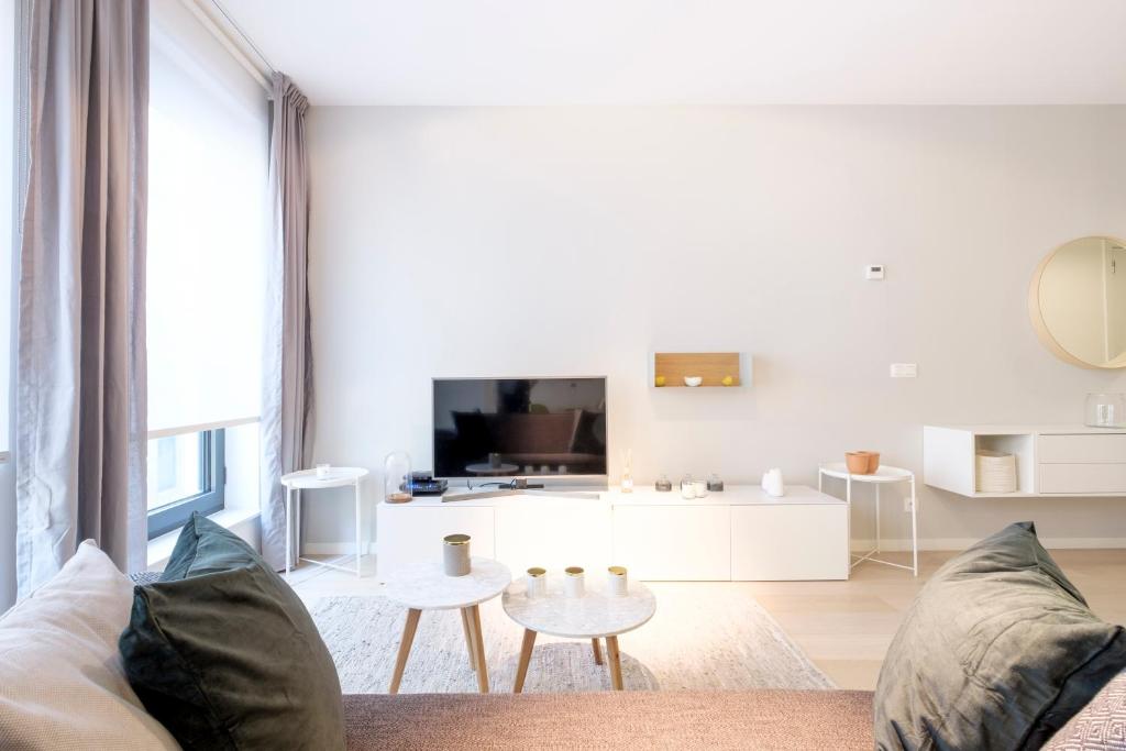 un soggiorno bianco con divano e tavolo di Brussels city flats a Bruxelles
