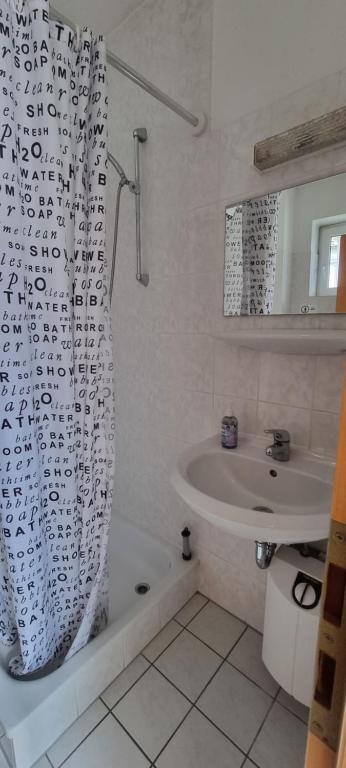 a bathroom with a shower curtain and a sink at Appartement Ernst in Celle