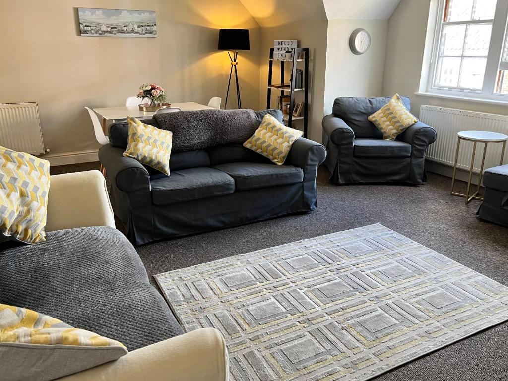 una sala de estar con 2 sofás y una alfombra en Stylish -2 Bed -Heart of the City - Parking- Wi-fi- Award Winning- Grade II Listed, en Norwich