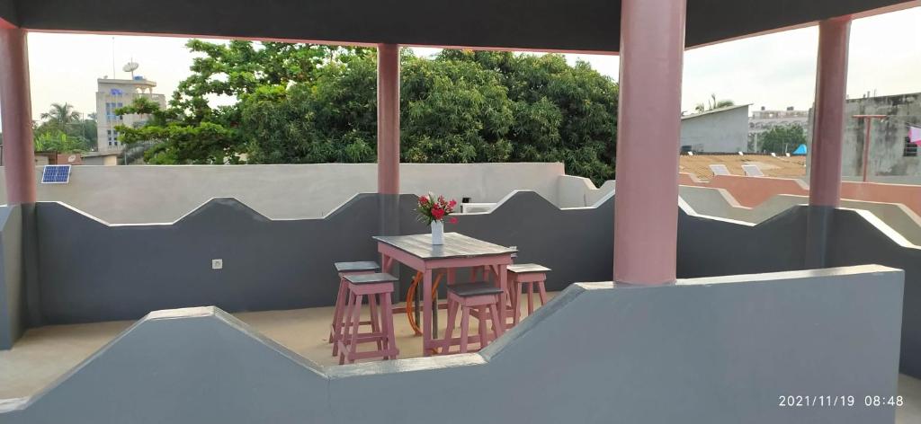 eine Terrasse mit einem Tisch und Stühlen auf dem Balkon in der Unterkunft Bethel House 2 Villas in Abomey-Calavi