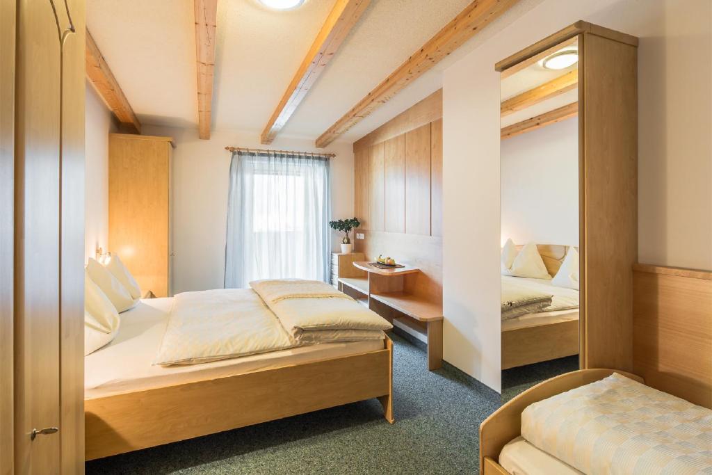 um quarto com 2 camas e um espelho em Residence Pfeifhofer em Campo Tures