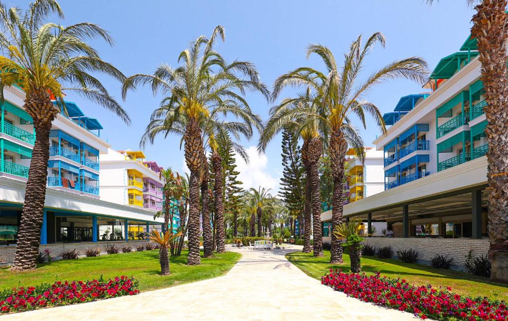 a walkway with palm trees in front of a building at Crystal Paraiso Verde Resort & Spa - Ultimate All Inclusive in Belek
