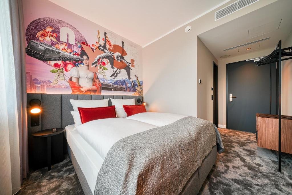 um quarto com uma cama grande e um quadro na parede em NYCE Hotel Hannover em Hanôver