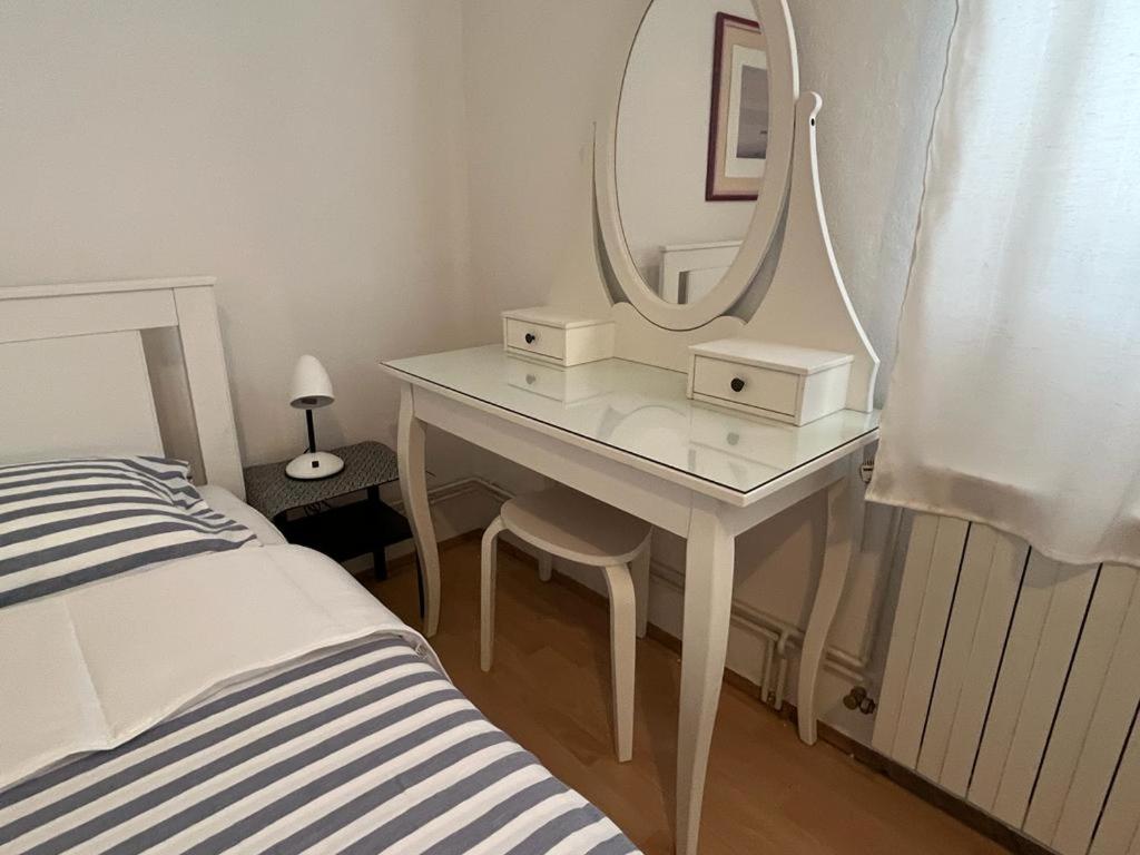 a white dressing table with a mirror next to a bed at RETRO Apartments in Bjelovar