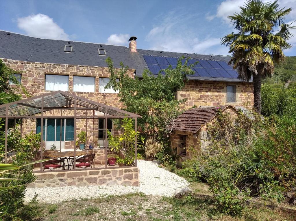 uma casa de tijolos com painéis solares no telhado em Le palmier d'Alice em Collonges-la-Rouge