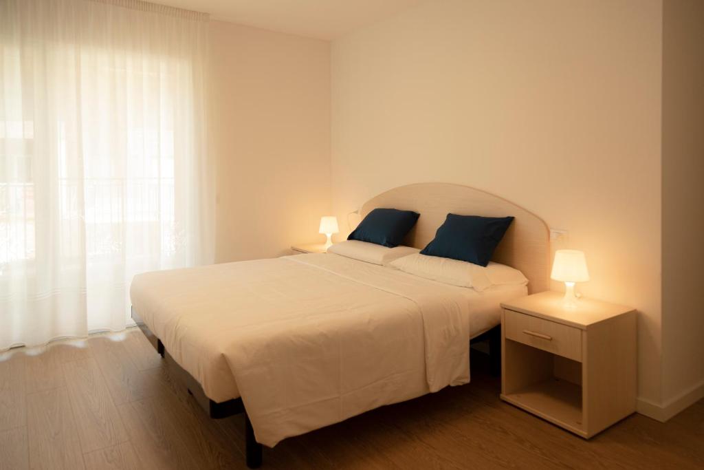 a bedroom with a large white bed with blue pillows at HOLIDAY APARTMENTS GIULIA - Blue in Pietramurata