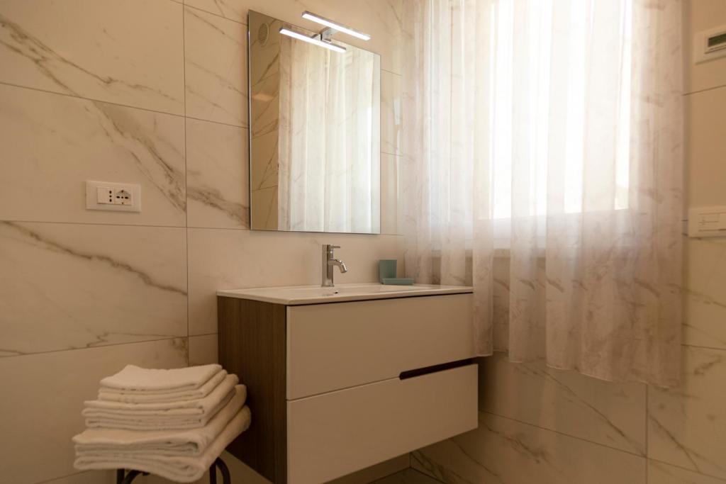łazienka z umywalką i lustrem w obiekcie HOLIDAY APARTMENTS GIULIA - Blue w mieście Pietramurata