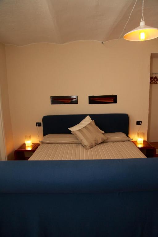 a bedroom with a bed with two lights on it at BBQ Lodge in Camogli