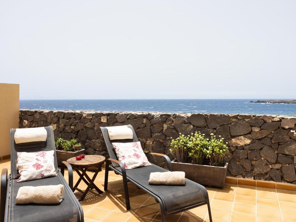 PillowAbroad - Dream sea view terrace Duplex في بوريس دي أبونا: كرسيين وطاولة أمام المحيط