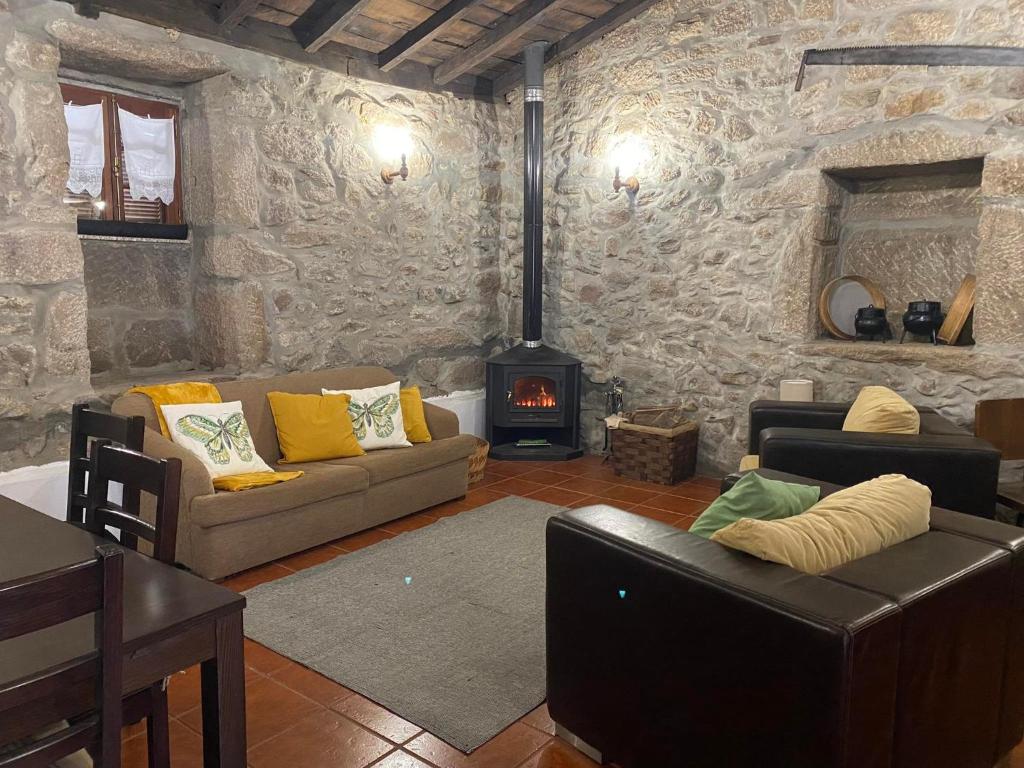 a living room with two couches and a fireplace at Casa da Pipela in Santo André