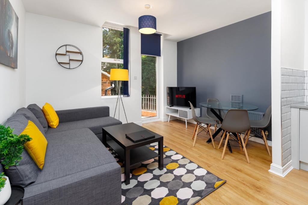 a living room with a gray couch and a table at FLATZY - Lovely Sefton Park Retreat in Liverpool