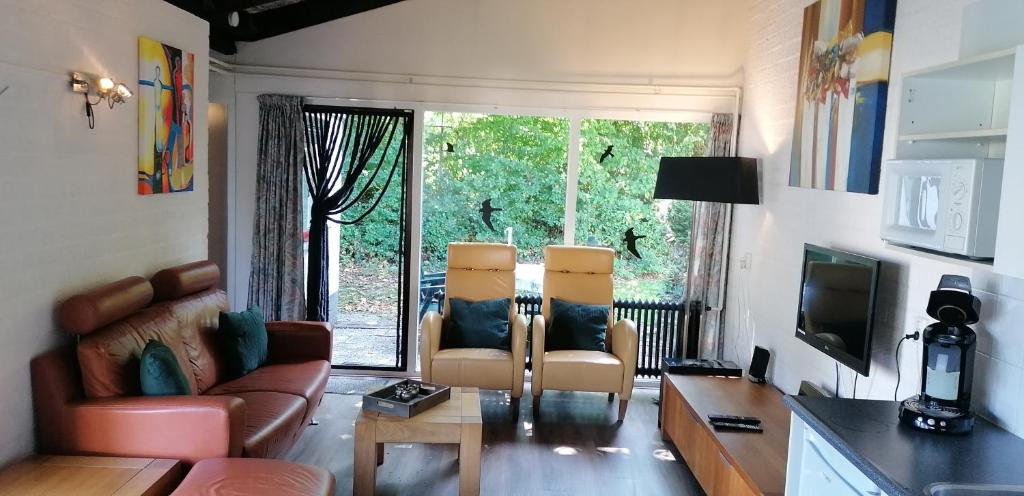 sala de estar con 2 sillas y sofá en Vakantiebungalow in het Limburgse Heuvelland en Simpelveld