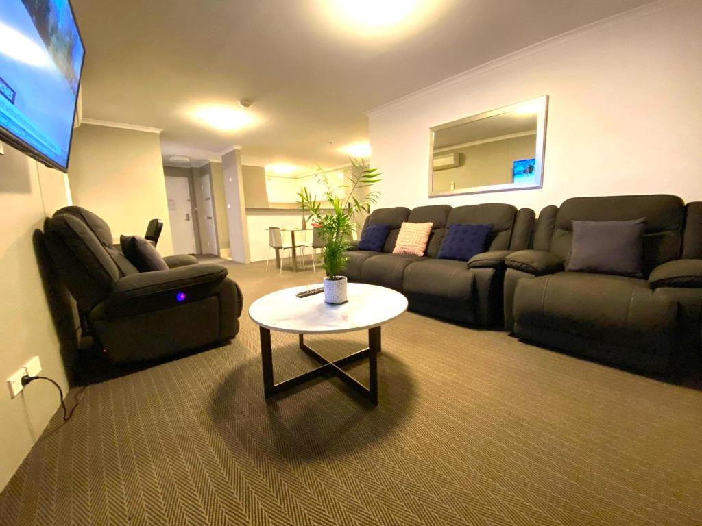 een woonkamer met een bank en een tafel bij 2 Bed 2 Bath Apartment in Braddon, Canberra - Pool, Gym and Free Parking in Canberra