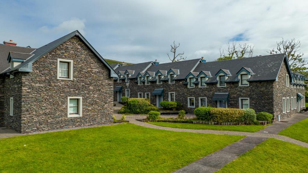 ディングルにあるDingle Courtyard Holiday Homes 3 Bedの緑の芝生のある大きなレンガ造りの建物