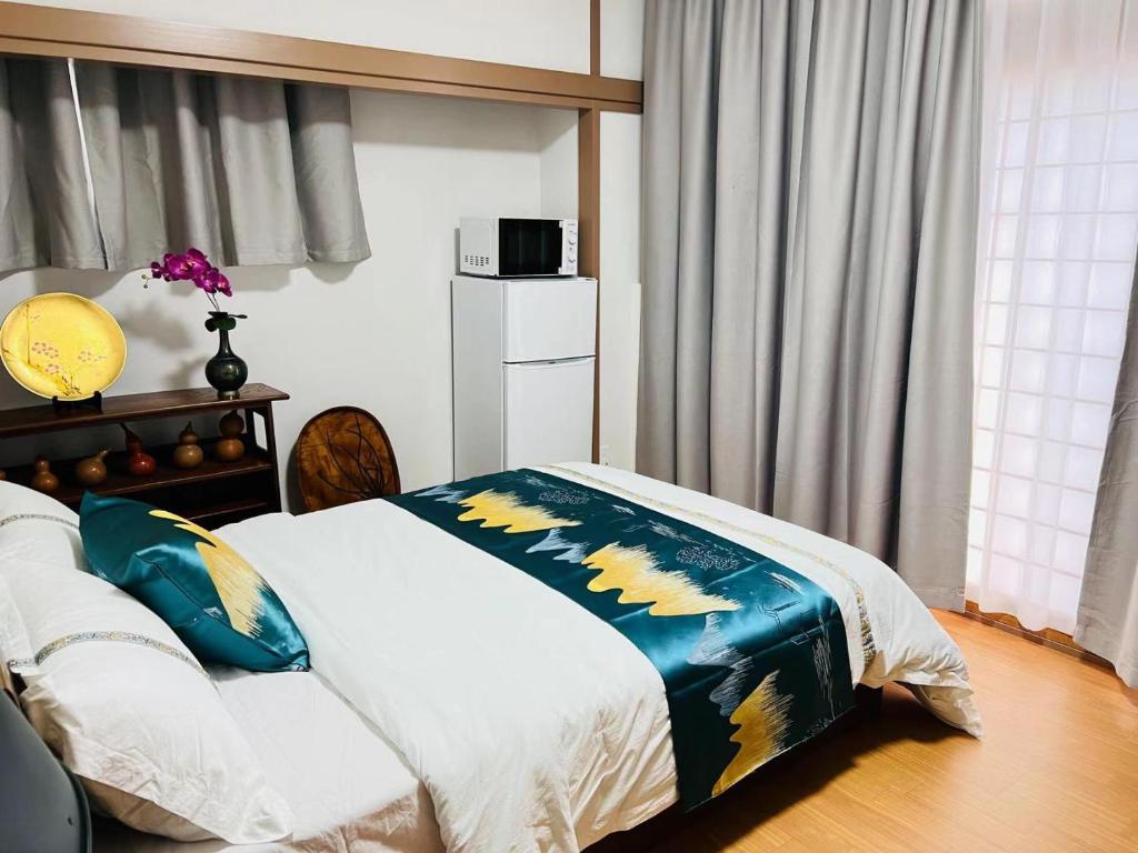 a bedroom with a bed with a blue and yellow blanket at 福宿 Fukuinn 201号室 in Takamatsu