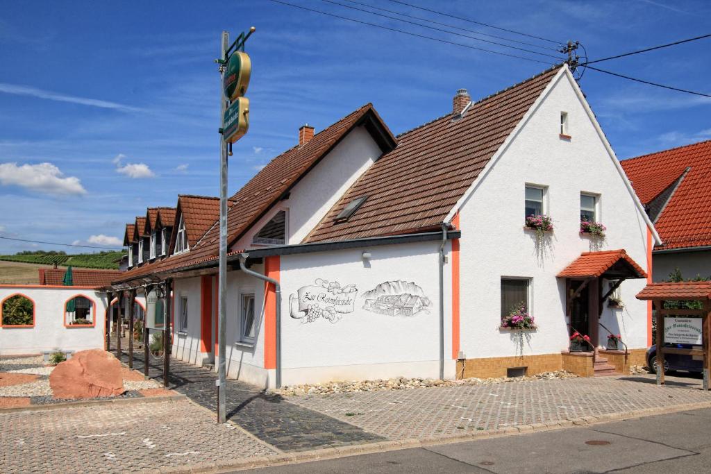 a white building with a mural on the side of it at Zur Rotenfelsstube in Traisen