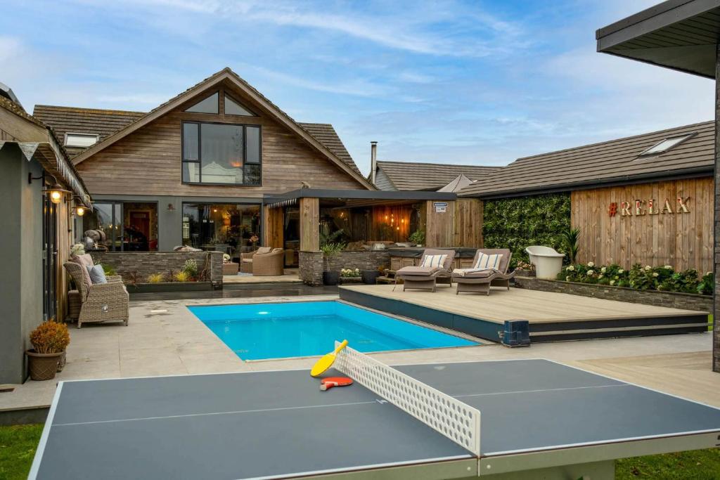 a backyard with a pool and a house at Deer Lodge in Lymington