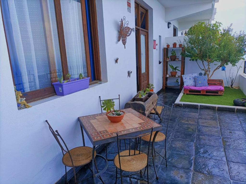 taras ze stołem, krzesłami i kanapą w obiekcie La Casita del acantilado w mieście Puerto de la Madera