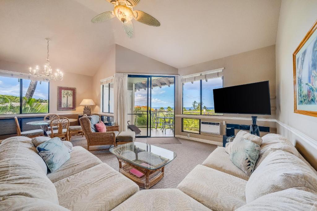 a living room with a couch and a flat screen tv at Wailea Grand Champions 58 in Wailea
