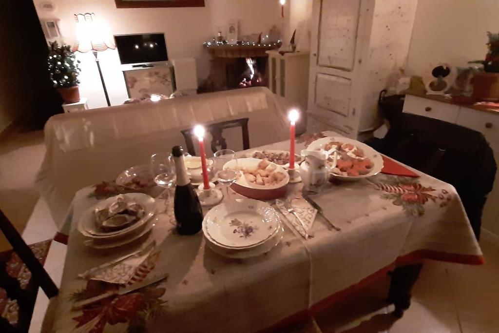 un tavolo con piatti e candele su di esso con una tovaglia di L' incantevole Tana di Oto a Ovindoli