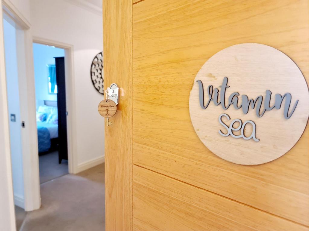 ラムズゲートにあるVitamin Sea Beachfront Apartment Ramsgate - Sleeps 4のビタミン海を読む扉の看板