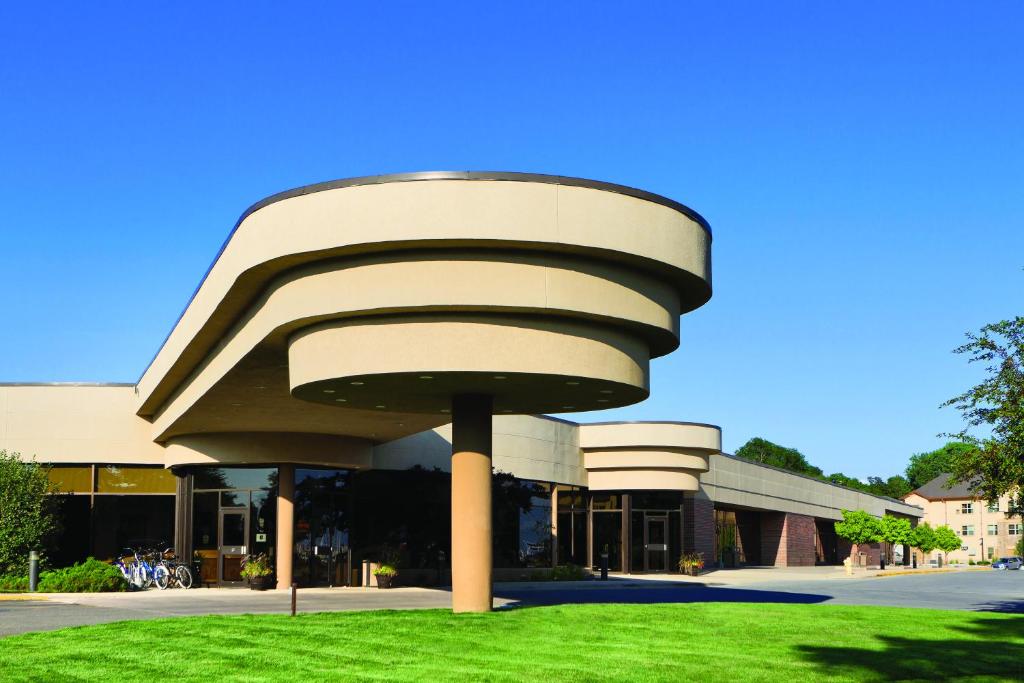 a building with a curved roof on the grass at Ramkota Hotel Pierre in Pierre