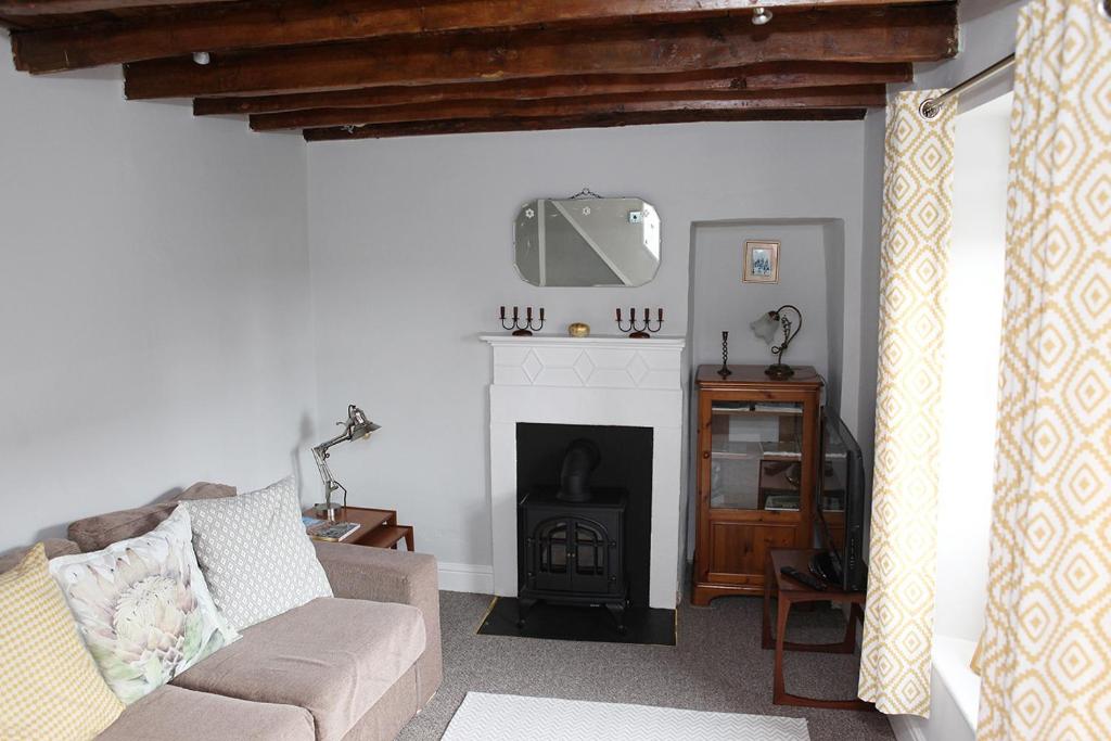 sala de estar con sofá y chimenea en Millgate Cottage in the heart of Richmond en Richmond