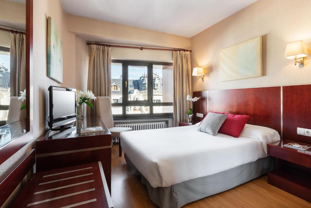 una habitación de hotel con una cama y un televisor en Crisol Riosol, en León