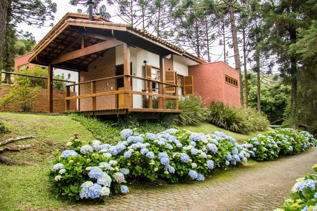 uma casa com um ramo de flores à frente dela em Barra do Bié Suítes em Cunha