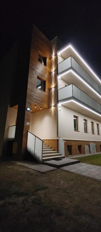 a large building with a staircase in front of it at night at Apartamenty ELIASZ in Ustronie Morskie