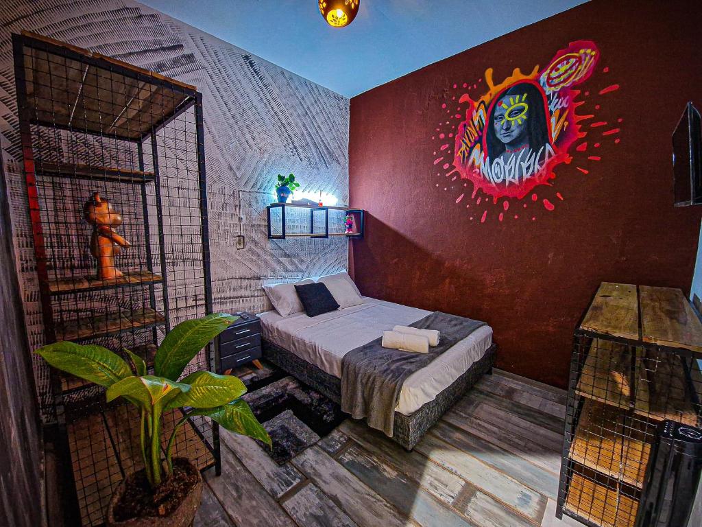 Un dormitorio con una cama con un cuadro en la pared. en Urban Hostal Bar, en Bucaramanga