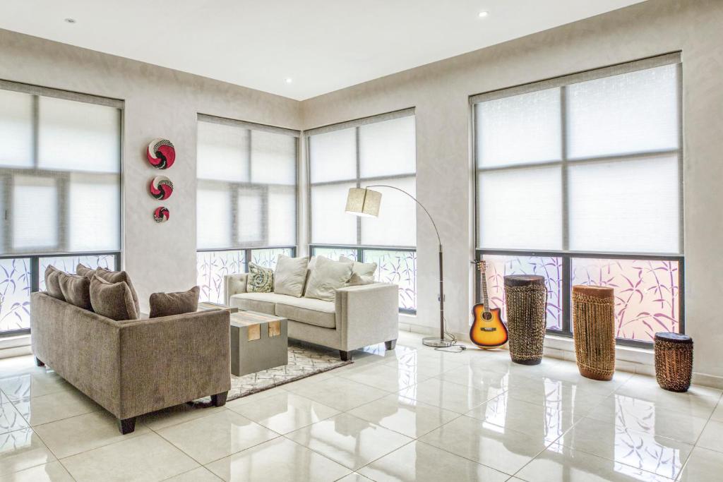 - un salon avec un canapé et une guitare dans l'établissement Virunga Inn Resort & Spa, à Kinigi