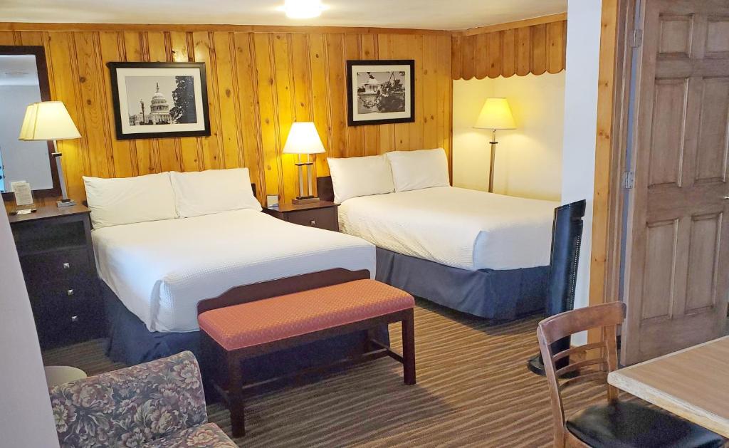 a hotel room with two beds and a table at Teton Court Motel in Pinedale