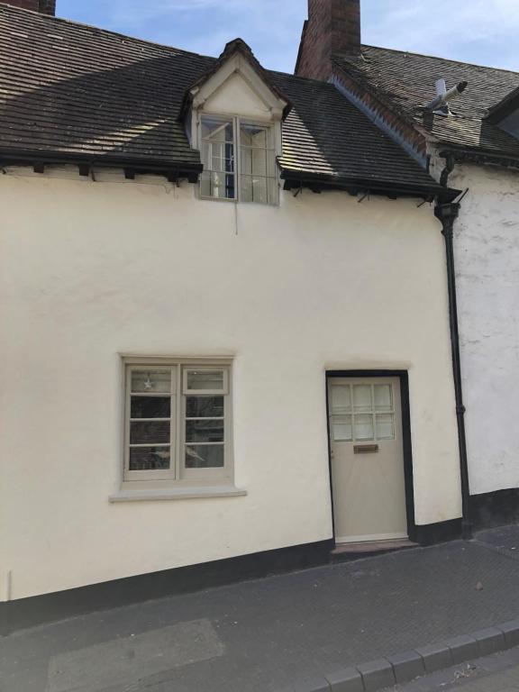 ein weißes Haus mit einer Tür und zwei Fenstern in der Unterkunft Shining Star, Cartway River Views in Bridgnorth