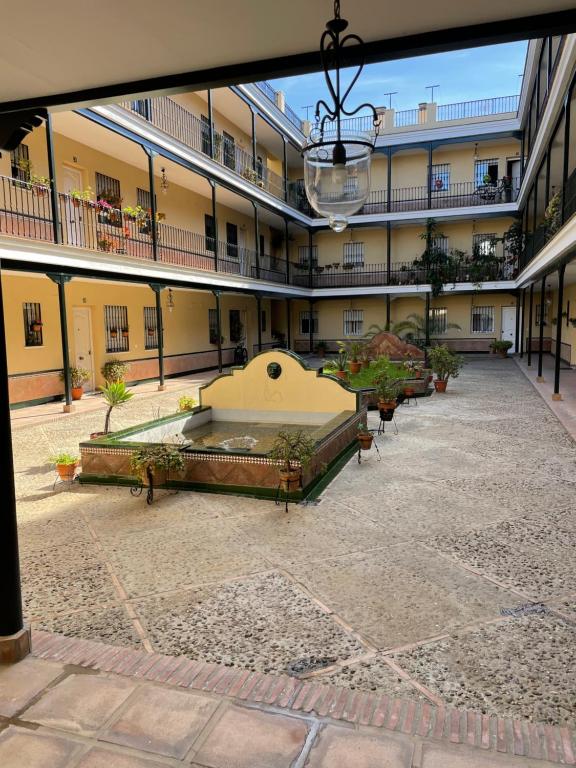un patio vacío de un edificio de apartamentos con una fuente en Apartamento en calle Rocio-Triana, en Sevilla