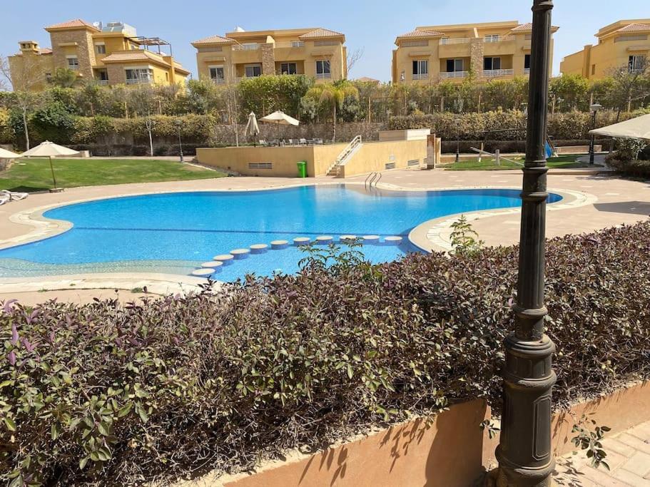 a swimming pool with a light pole and some bushes at Lovely 3-Bedroom Rental Unit with Pool in Sheikh Zayed