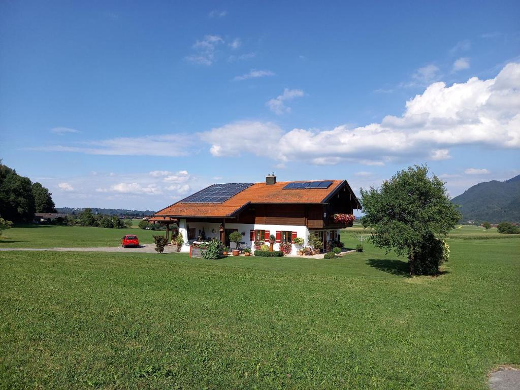 a house with a solar roof on a green field at Haus Maier in Marquartstein